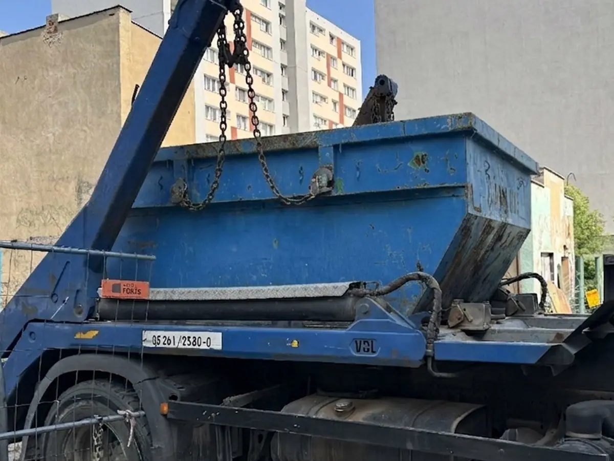 Kontener zdejmowany z samochodu na osiedlu bloków w Poznaniu